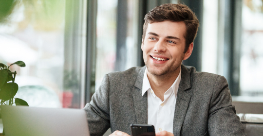 Mann mit Mobiltelefon im Büro