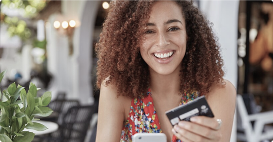 Frau mit Mobiltelefon und Bankkarte